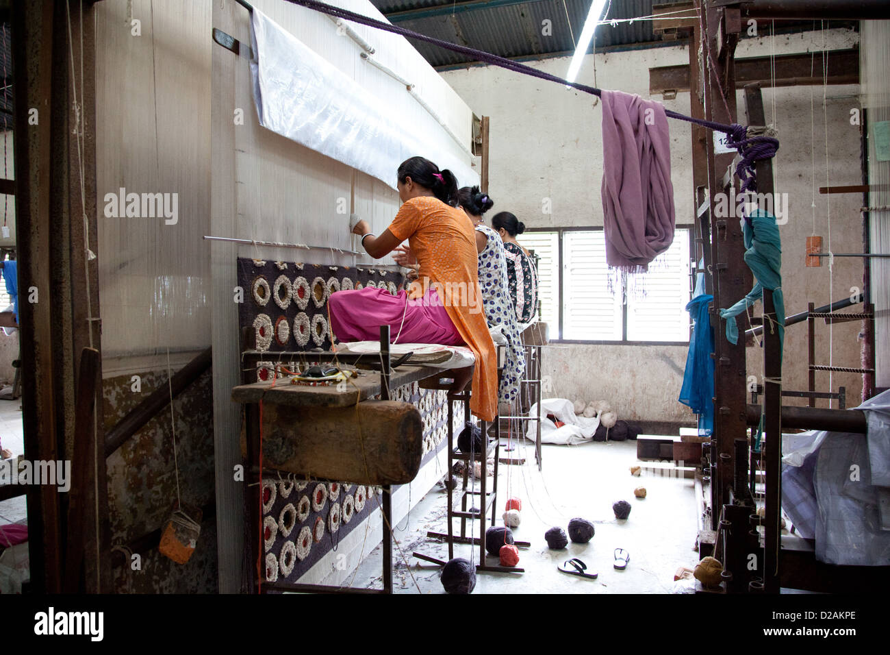 Lavoratori sul telaio. I tappeti sono realizzati alla vecchia maniera con i lavoratori la tessitura utilizzando telai enorme e la tessitura a mano. Foto Stock