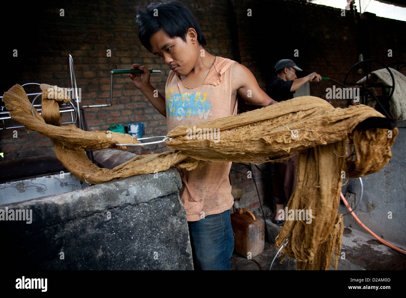 Un lavoratore tira fuori la lana di un serbatoio di colorante a caldo. Il colorante viene riscaldata da caldaie di kerosene. Foto Stock