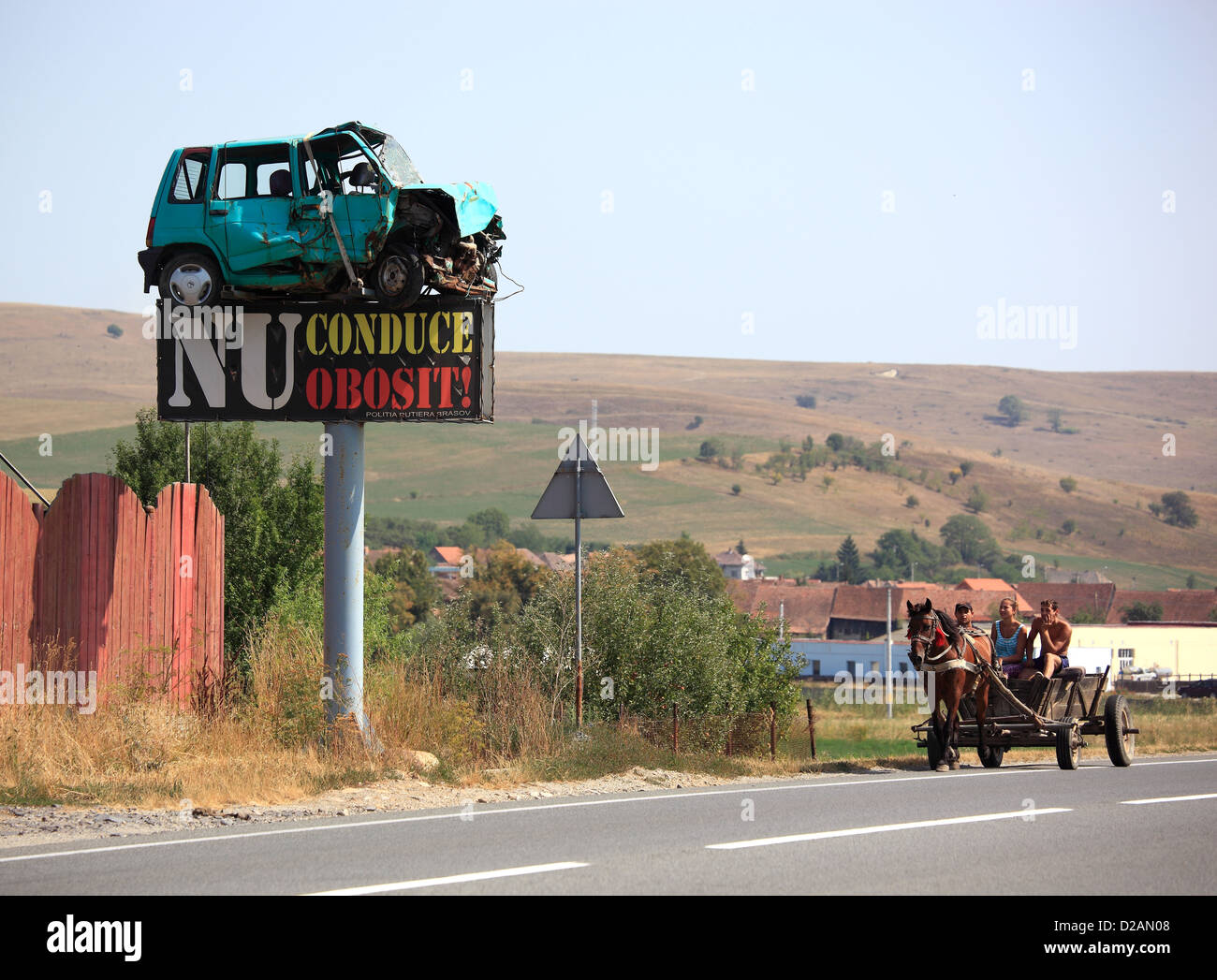 Pullman il passaggio di un segno di traffico con un relitto auto su una strada nella contea di Brasov, Romania Foto Stock