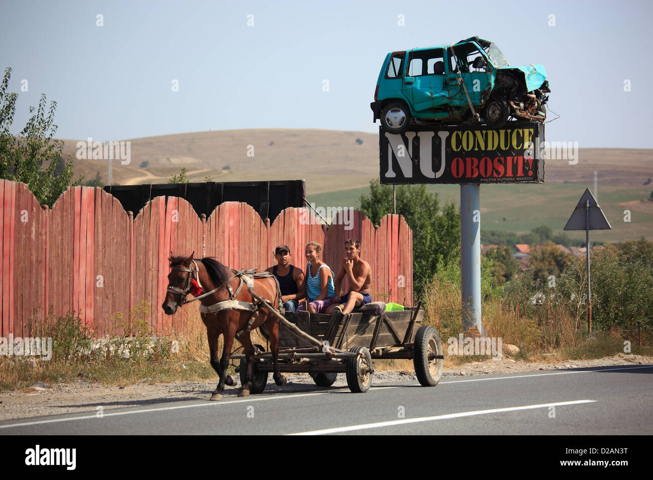 Pullman il passaggio di un segno di traffico con un relitto auto su una strada nella contea di Brasov, Romania Foto Stock