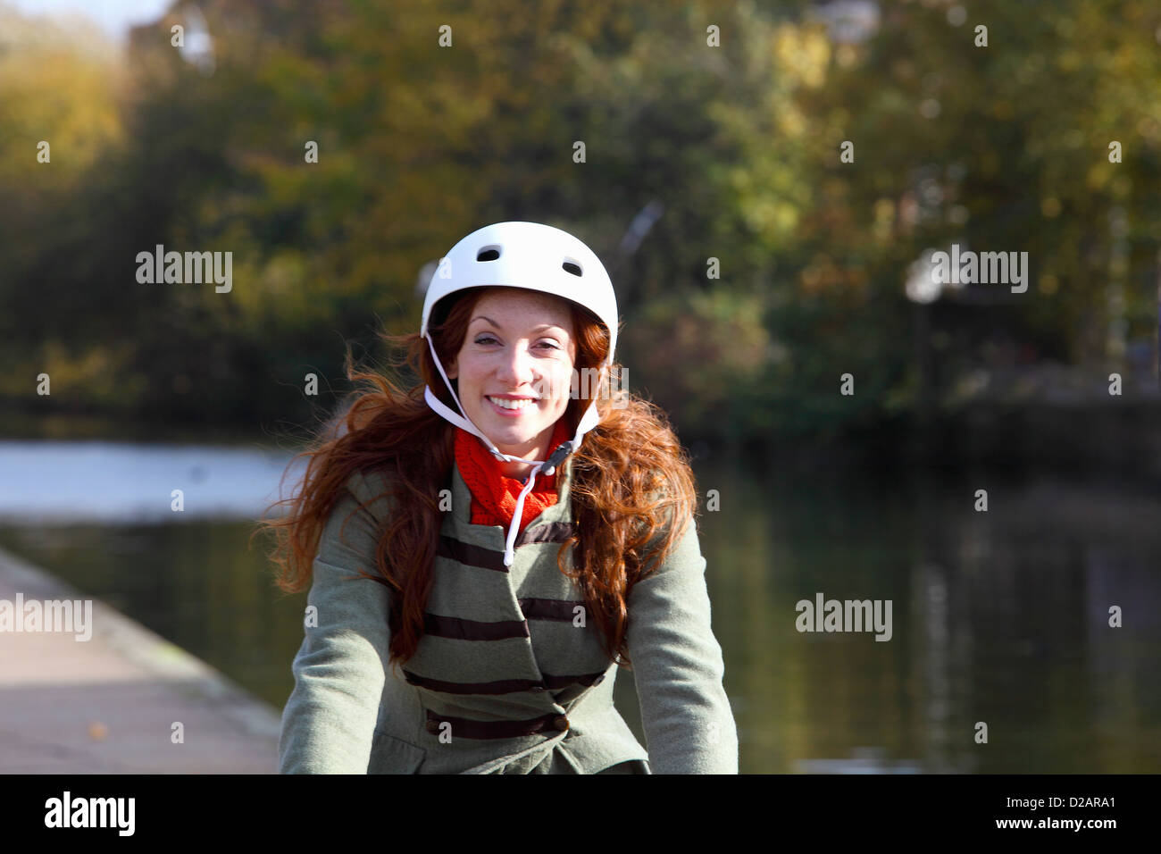 Donna Bicicletta Equitazione lungo waterfront Foto Stock