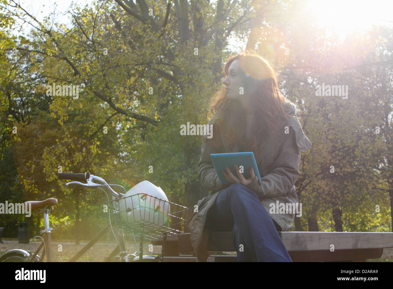 Donna seduta con la bicicletta in posizione di parcheggio Foto Stock