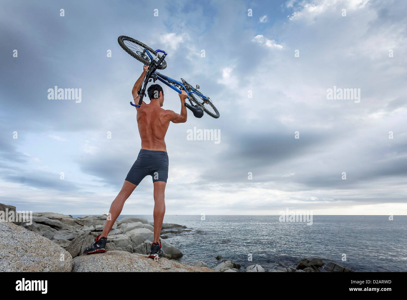 Uomo con bicicletta sul boulder Foto Stock