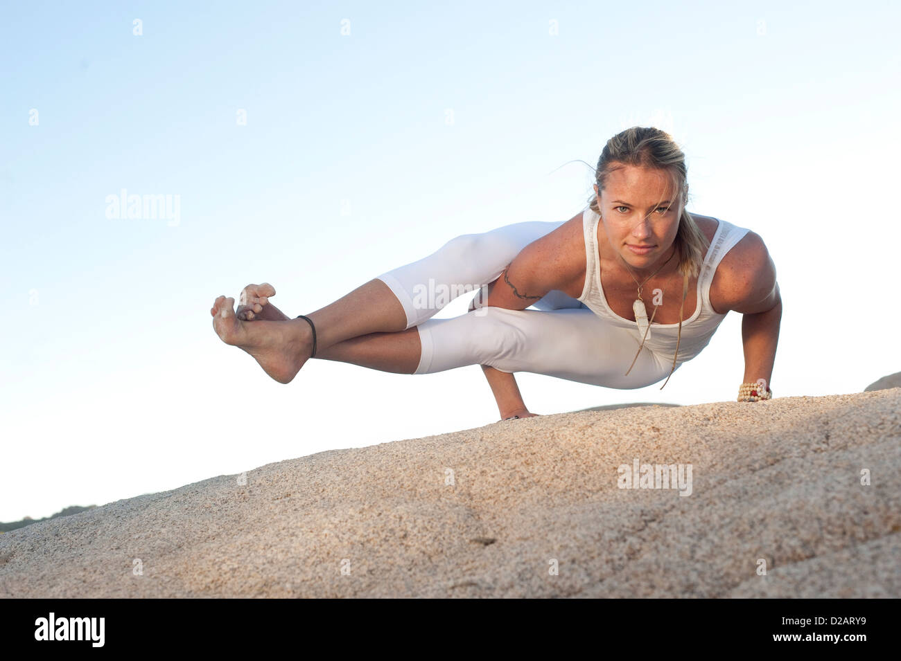 Auto determinato donna nella postura yoga Astavakrasana. Foto Stock