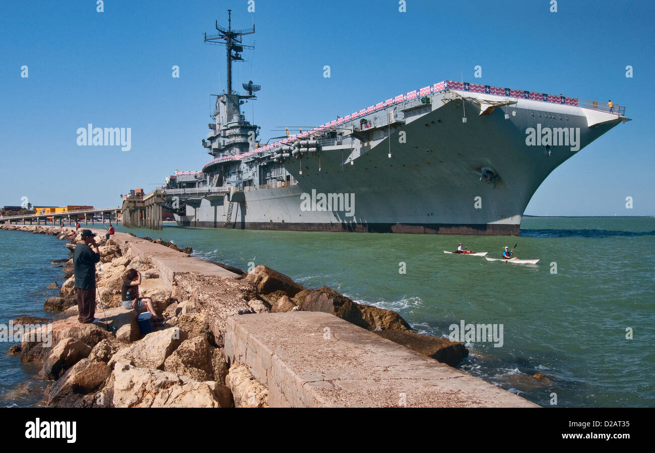 Kayakers passando WW2 portaerei, pescatori al molo, USS Lexington museo sulla baia di Corpus Christi, costa del Golfo, Texas, Stati Uniti d'America Foto Stock