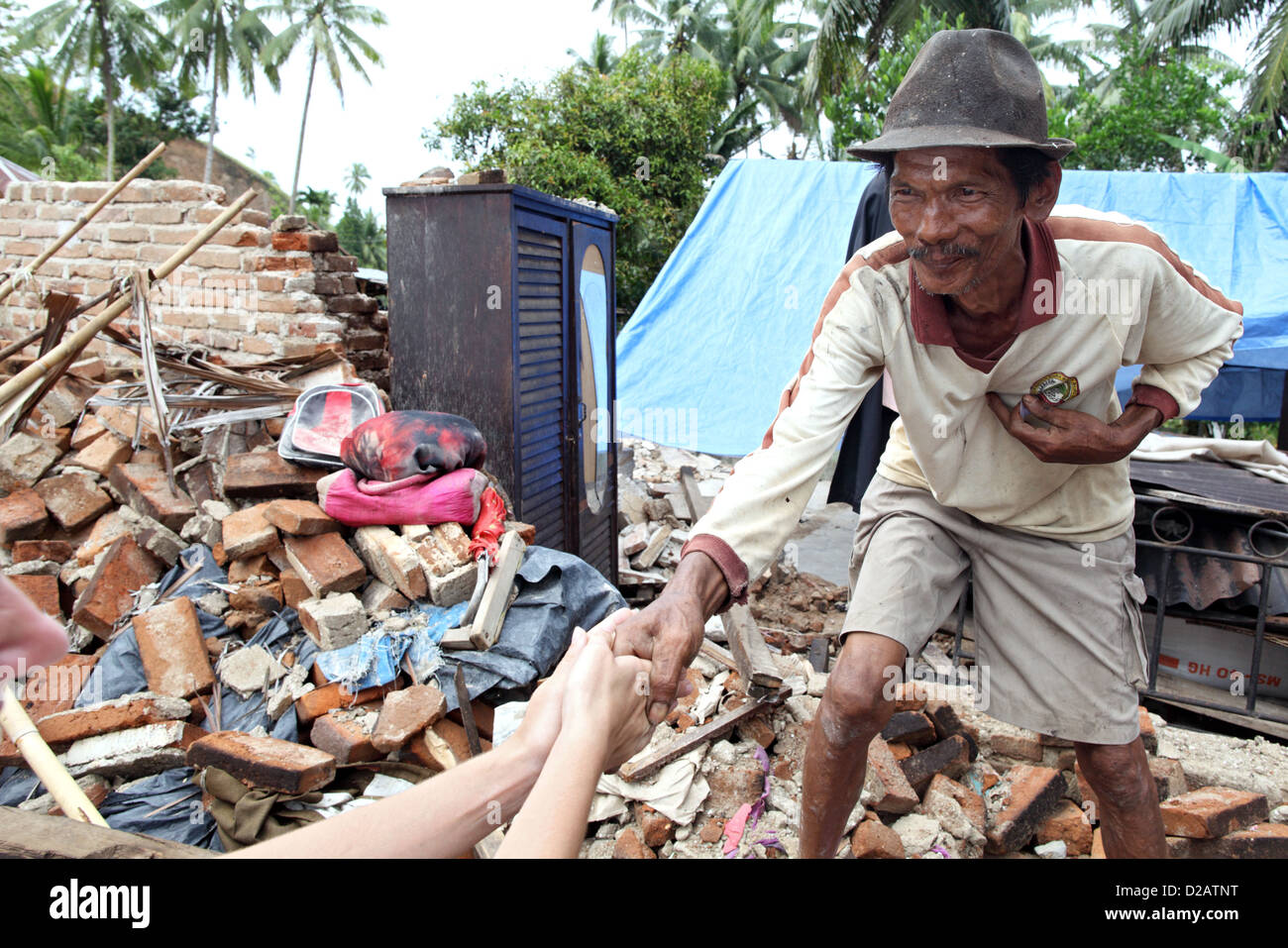 Sungai Rambai, Indonesia, un interessato uomo anziano davanti alla sua casa distrutta Foto Stock