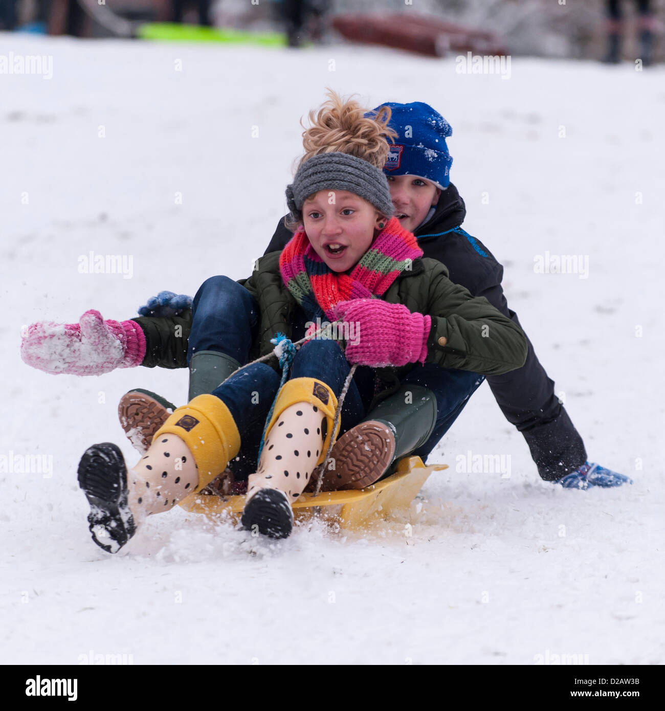 18 gennaio 2013. Due bambini di godere la neve su una slitta a Beccles, Suffolk, Regno Unito. Foto Stock