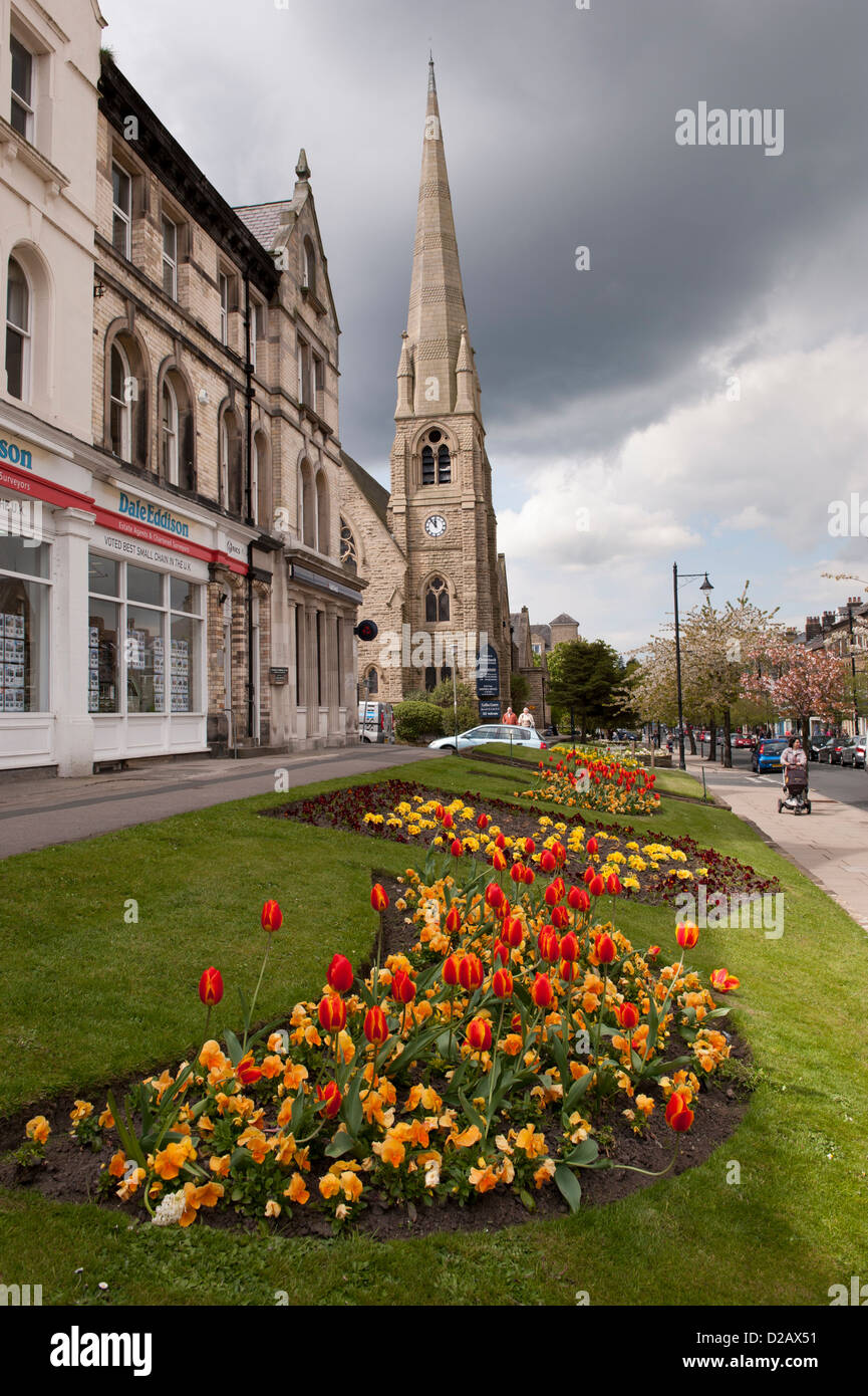 Vivaci e colorati fiori di primavera che fiorisce in aiuole da negozi di high street in scenic Town Center - The Grove, Ilkley, nello Yorkshire, Inghilterra, Regno Unito. Foto Stock