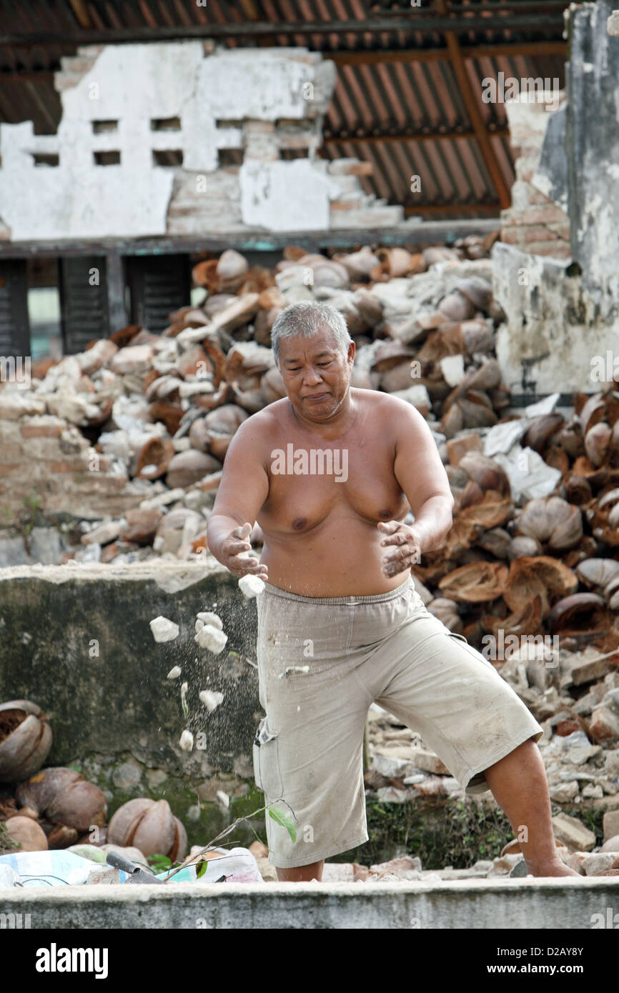 Pariaman, Indonesia, un uomo di fronte al suo distrutto casa nella zona del terremoto Foto Stock