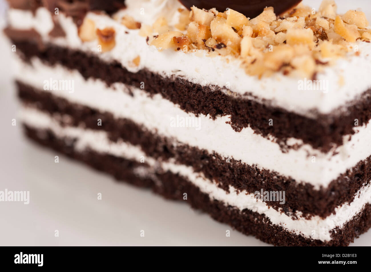 Primo piano dettaglio di una foresta nera stratificata gateau pan di spagna isolato su bianco Foto Stock