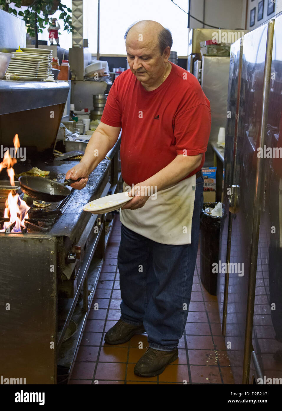 Detroit, Michigan - Il proprietario della bistecca Hut, un cucchiaio di grasso diner, fa le uova per un cliente di prima colazione. Foto Stock