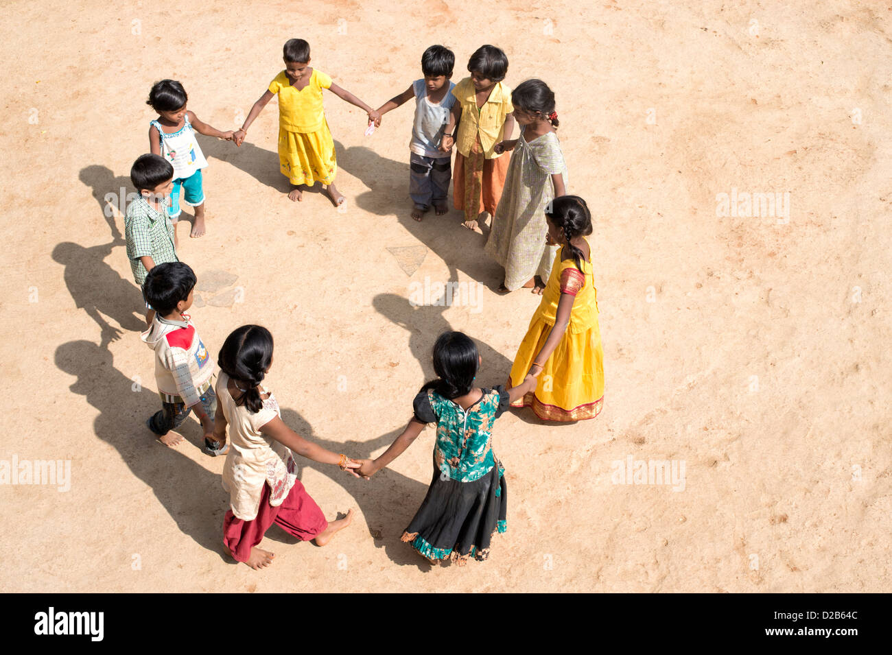 Villaggio indiano di bambini in un cerchio tenendo le mani per giocare. Andhra Pradesh, India Foto Stock