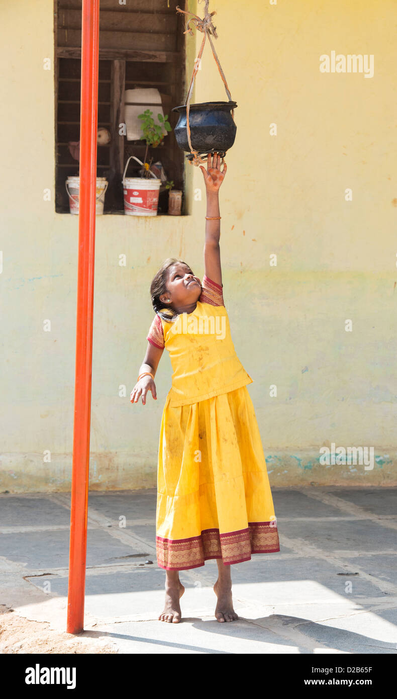 Villaggio indiano ragazza fino ad arrivare a memorizzato il cibo cotto al di fuori di casa sua. Andhra Pradesh, India Foto Stock