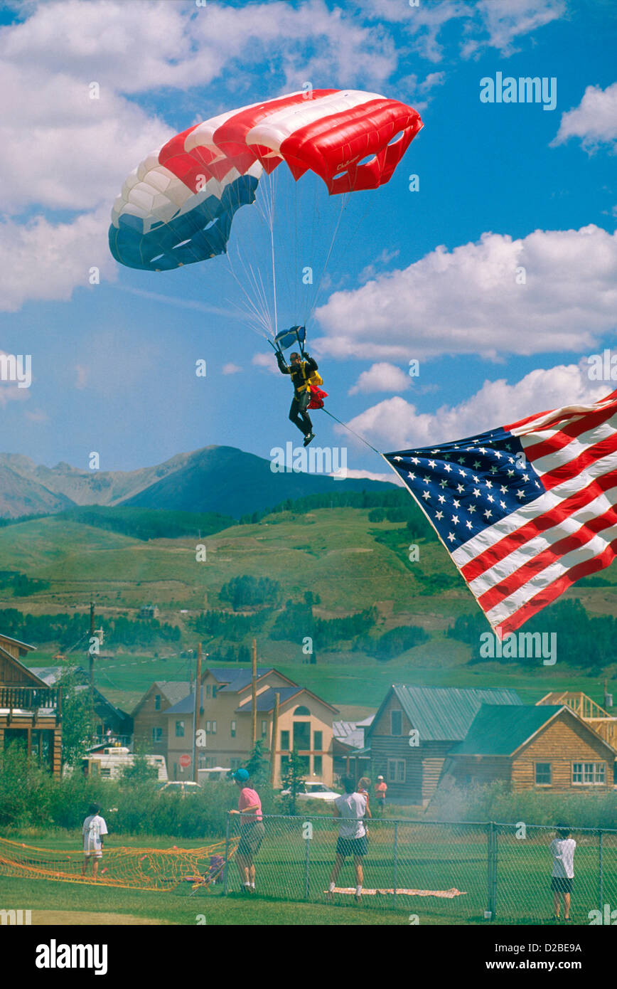 Colorado, Crested Butte. Uomo al paracadutismo con bandiera americana al weekend di antenna. Foto Stock