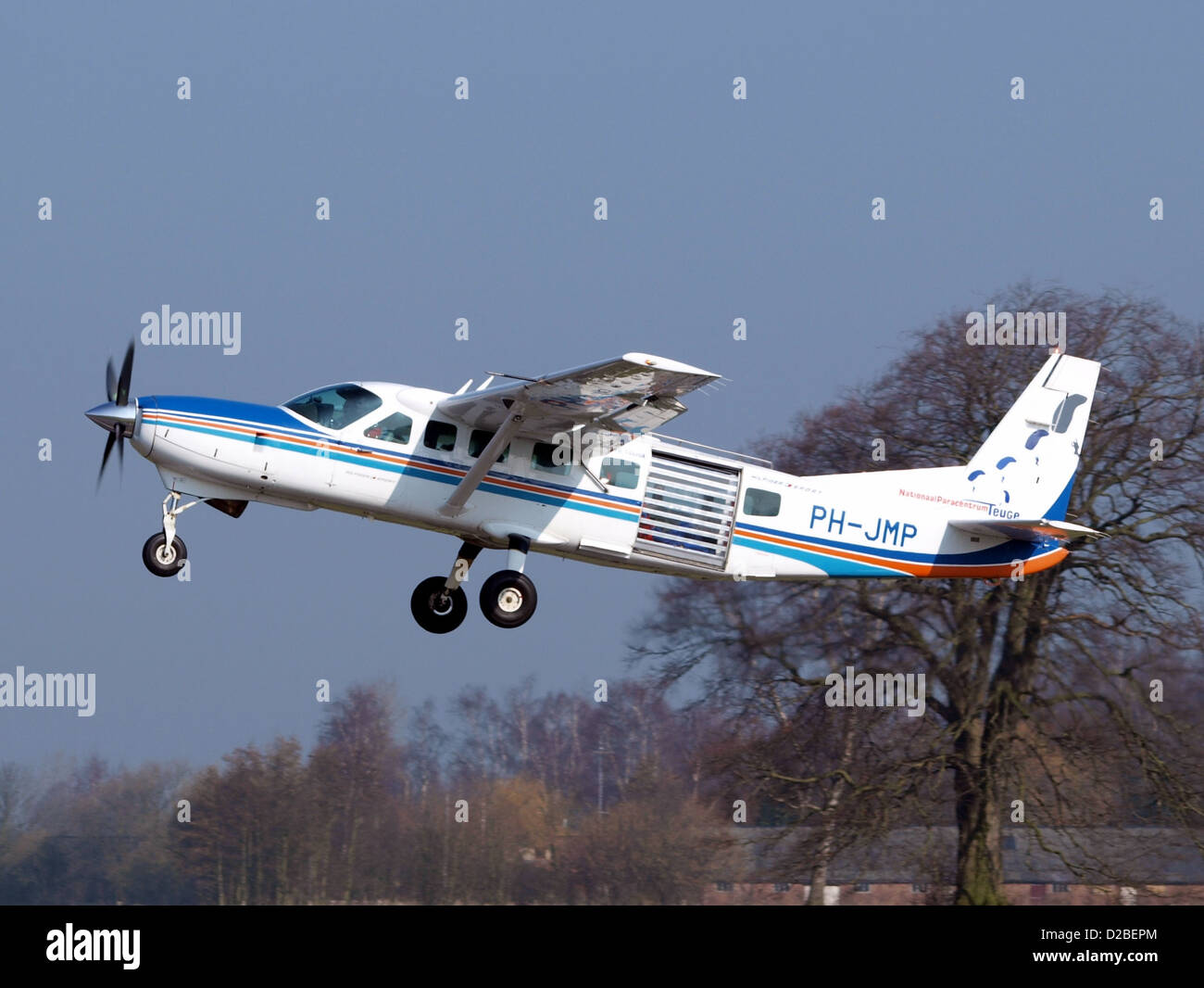 Il Cessna 208B, registrato PH-JMP, è un velivolo monomotore versatile progettato sia per il trasporto merci che passeggeri. Catturato qui in decollo a Teuge, è ampiamente utilizzato per i voli regionali e i servizi di trasporto merci a corto raggio. Foto Stock