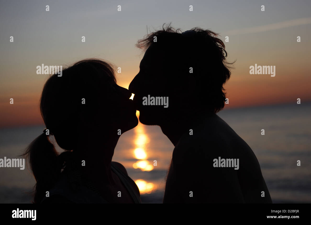 Kägsdorf, Germania, silhouette giovane baci al tramonto sul mare Foto Stock