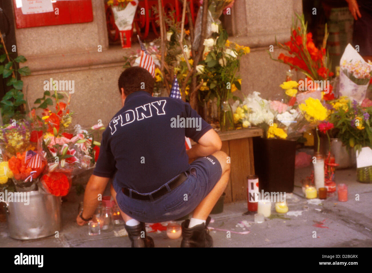 La città di New York, 9/11/2001. Vigile del fuoco con memoriali dalla stazione antincendio #14 seguenti World Trade Center Attack Foto Stock