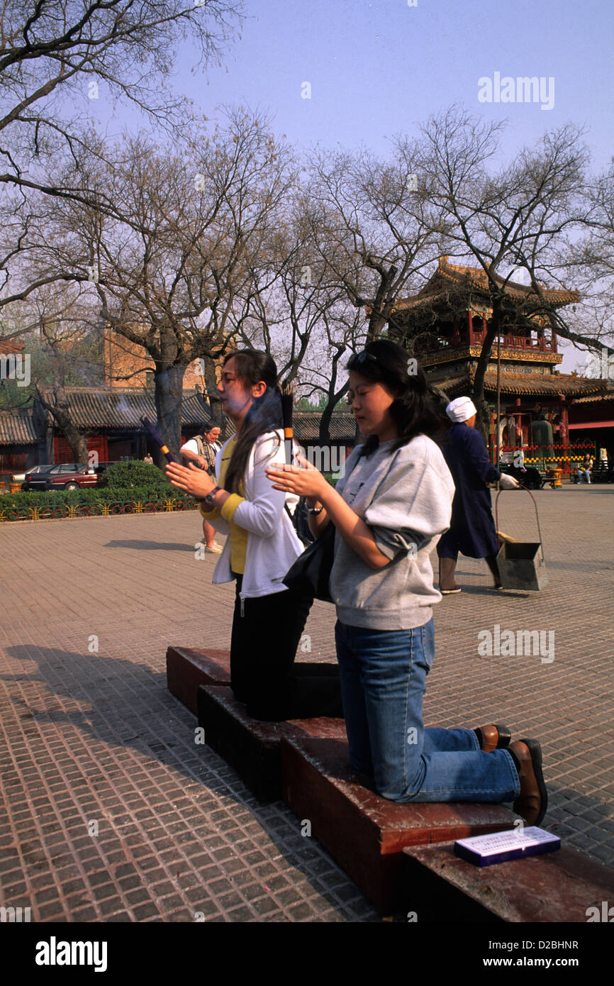 Cina, Pechino. Le donne in adorazione e bruciando incenso presso il Tempio Lama Foto Stock