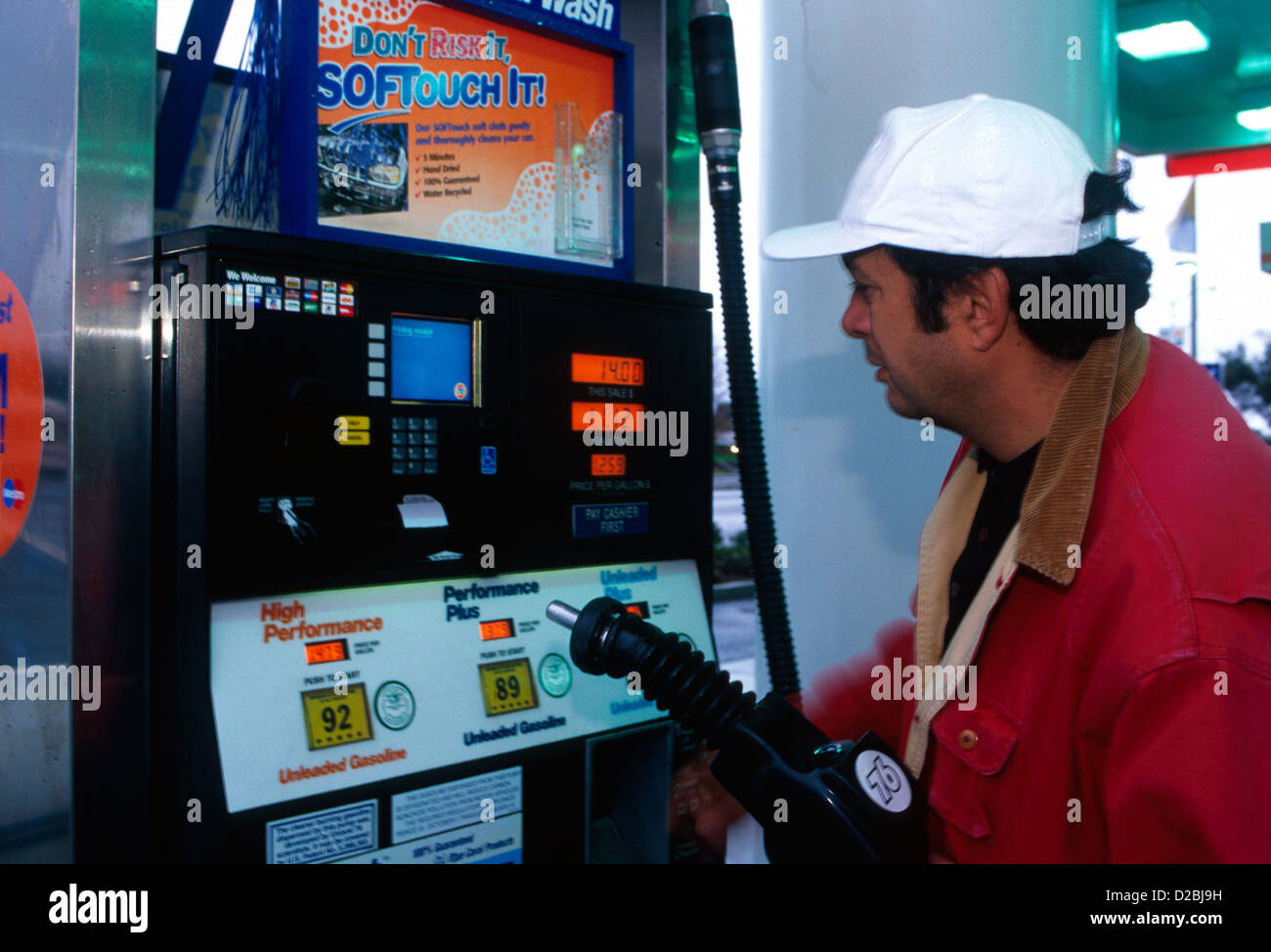 Uomo che utilizza automatizzato di pompa in corrispondenza della stazione di gas. Accetta di credito o carte di debito. Foto Stock