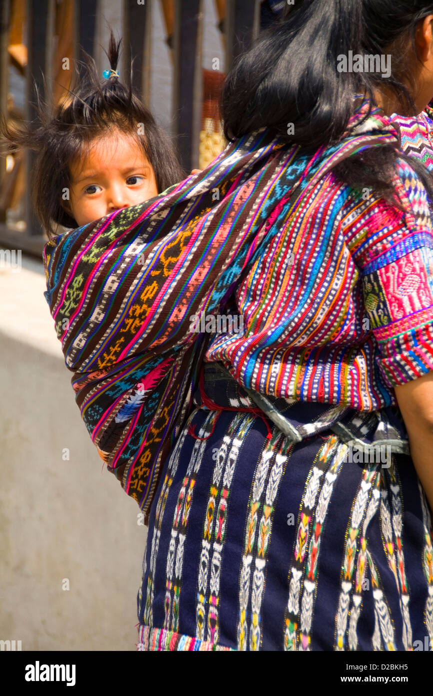 Guatemala, Solola. Donna in abito tradizionale bambino portando sulla sua schiena Foto Stock