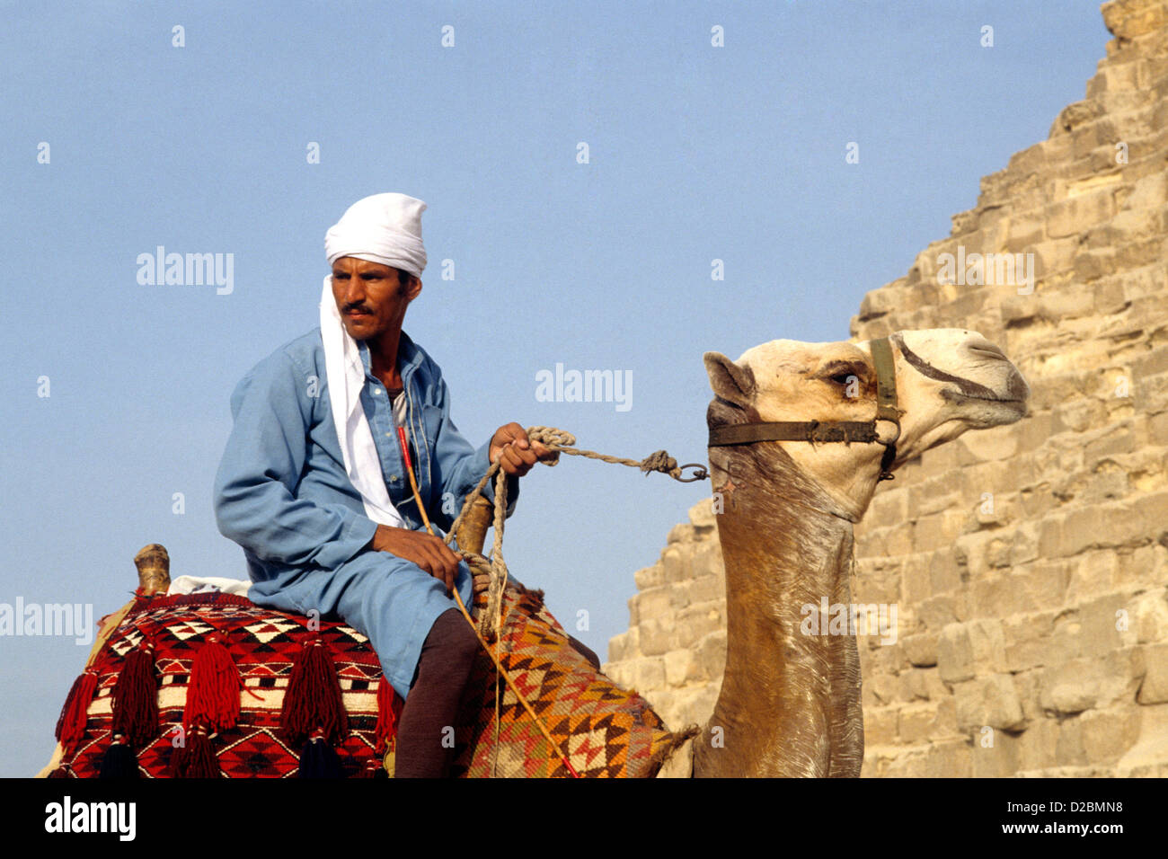Egitto Giza, Piramidi. Camel Rider Foto Stock