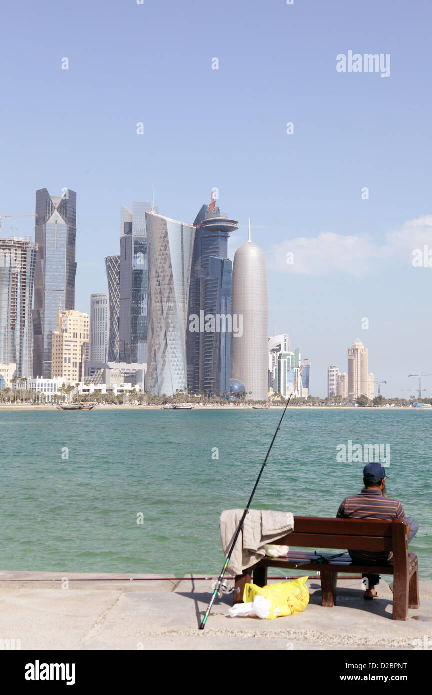 Un asiatico expat a Doha, in Qatar, si gode il suo sabato la pesca dalla Corniche nella baia di Doha Foto Stock
