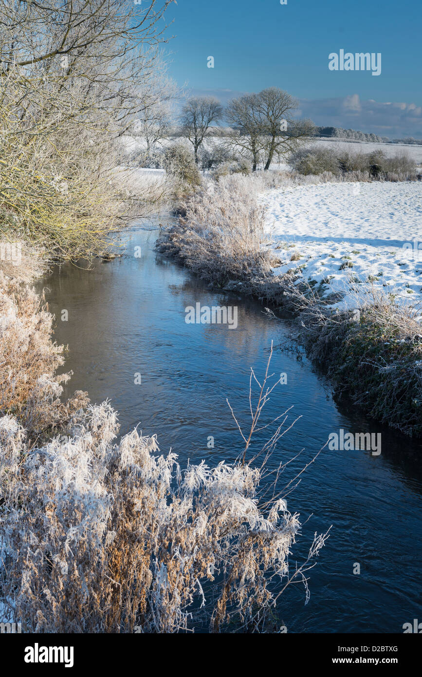 Fiume stiffkey fluente attraverso la coperta di neve pascolo, North Norfolk, Inghilterra Foto Stock