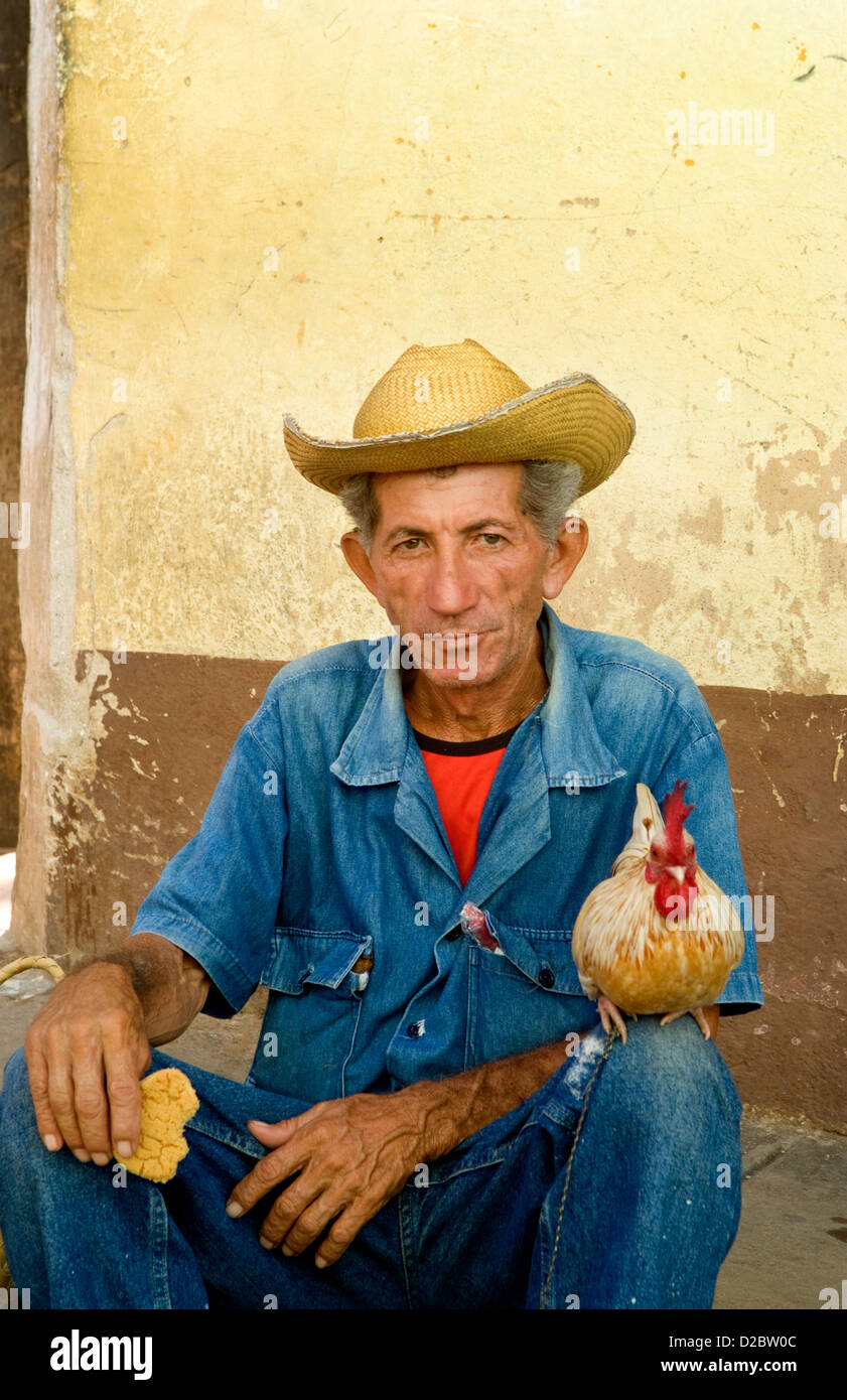 Uomo vecchio con il suo pollo su strade del vecchio villaggio di Trinidad, Cuba Foto Stock