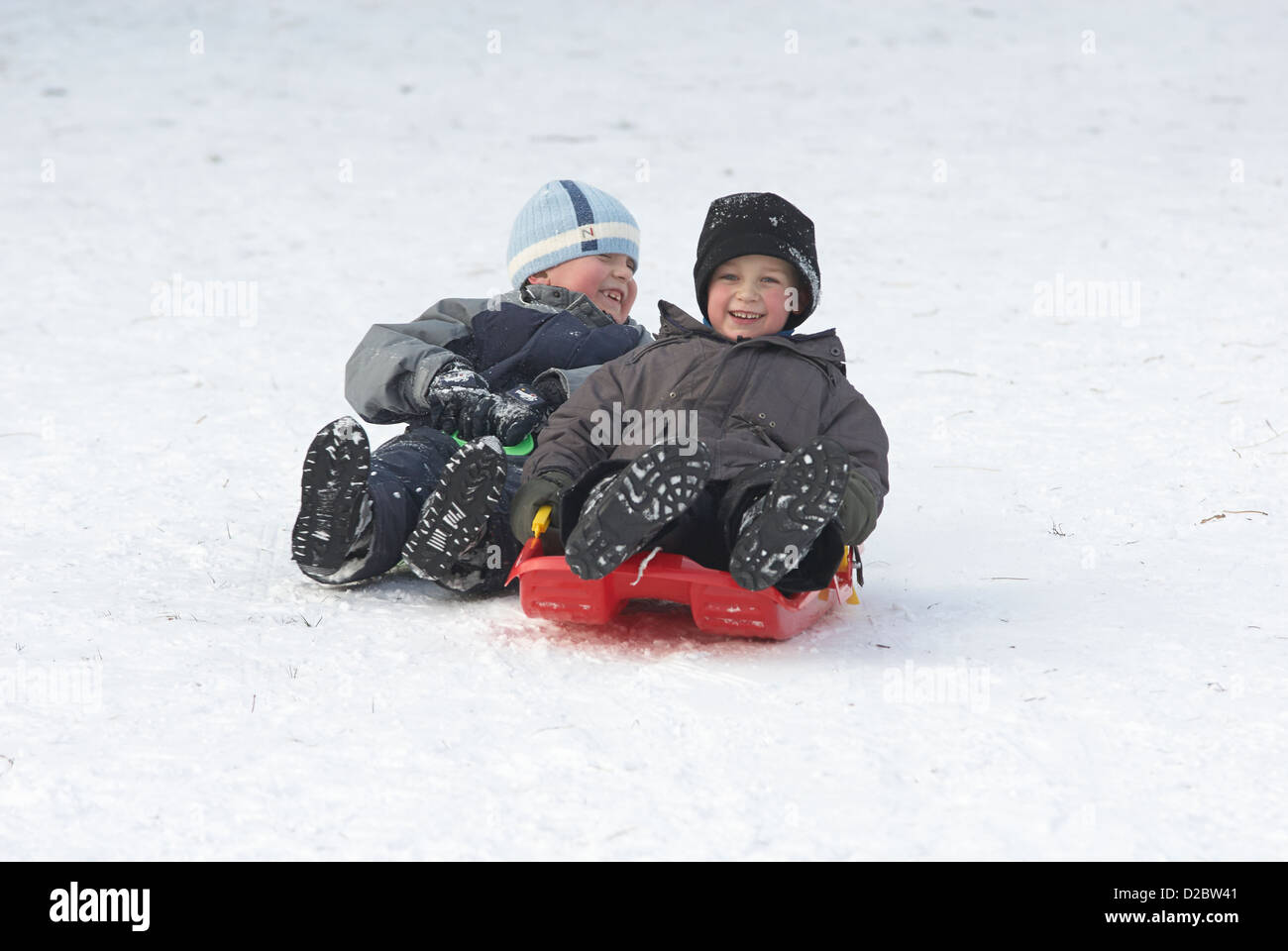 Bambino ragazzo (6-8) su una slitta di bob, neve stagione invernale Foto  stock - Alamy