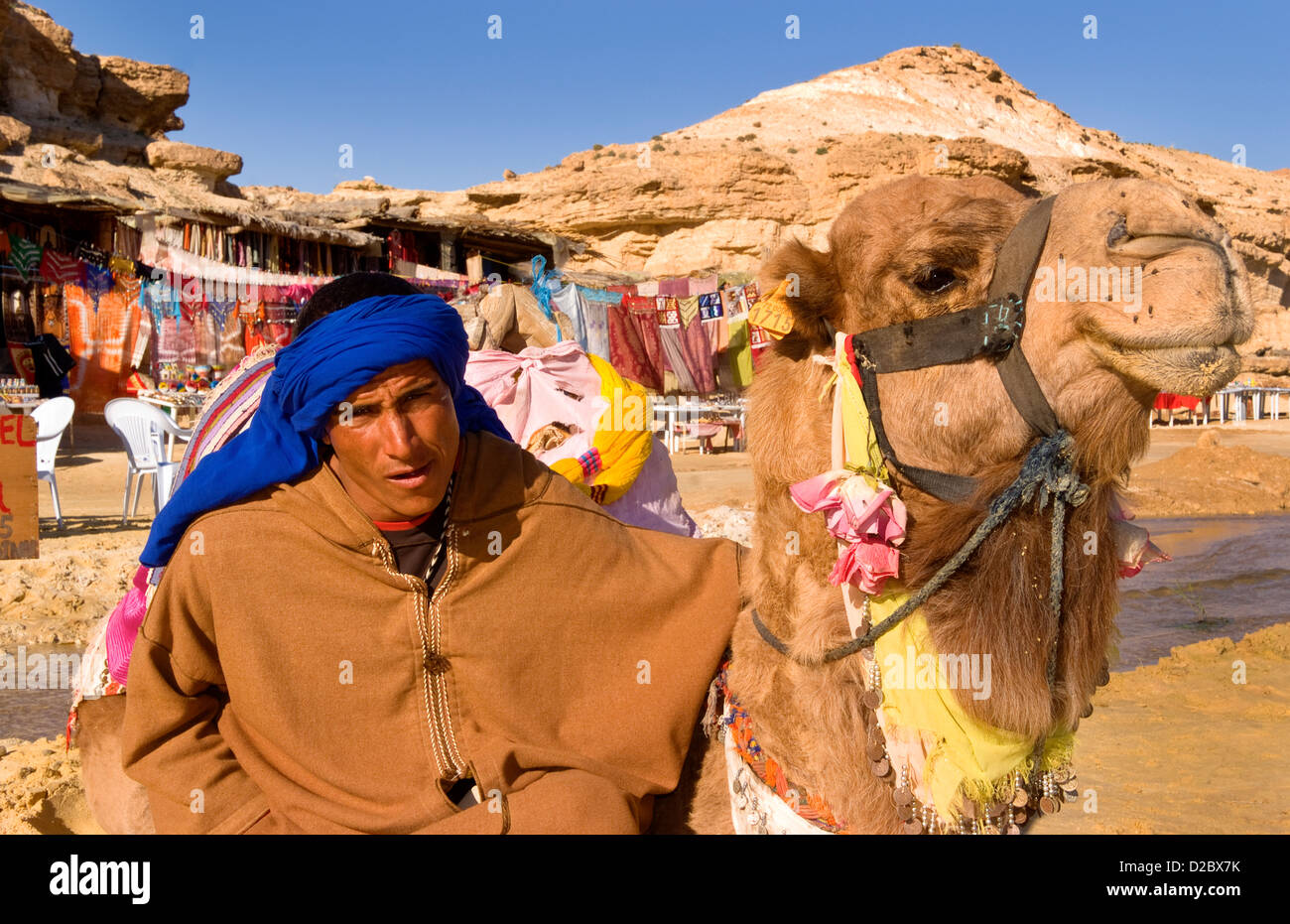 Il cammello e il beduino pilota, il Deserto del Sahara, Douz, Tunisia Foto Stock