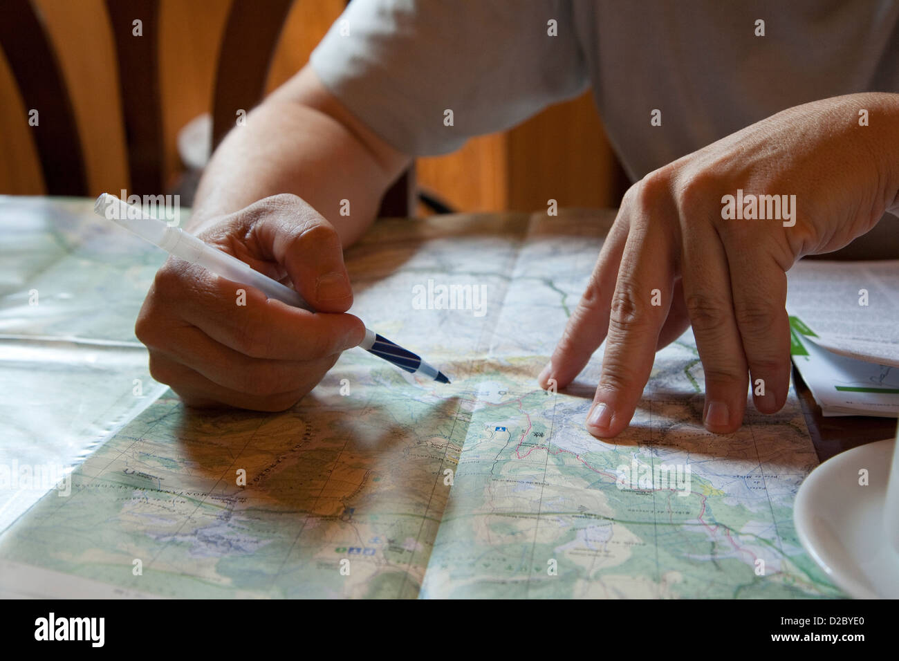 Uomo in una caffetteria esaminando una mappa del parco nazionale nel villaggio di Espot Foto Stock