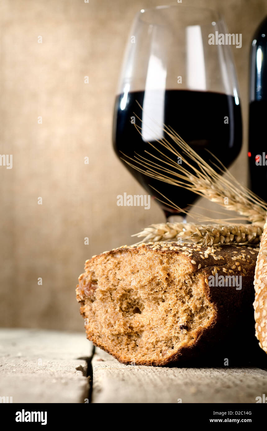 Vino, pane e grano sul tavolo di legno Foto Stock
