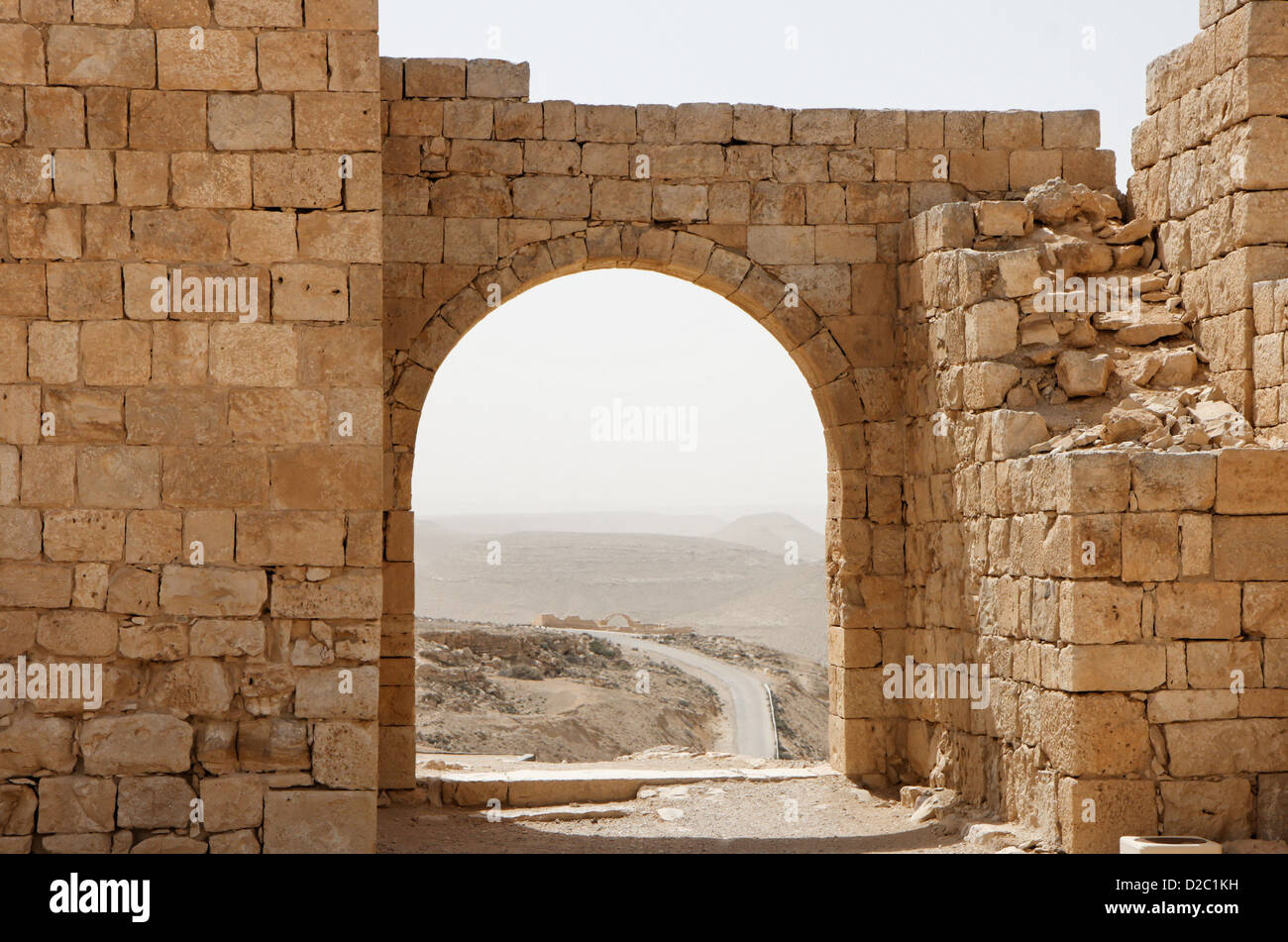 Antico arco di pietra e la parete con vista del deserto durante la tempesta di sabbia Foto Stock