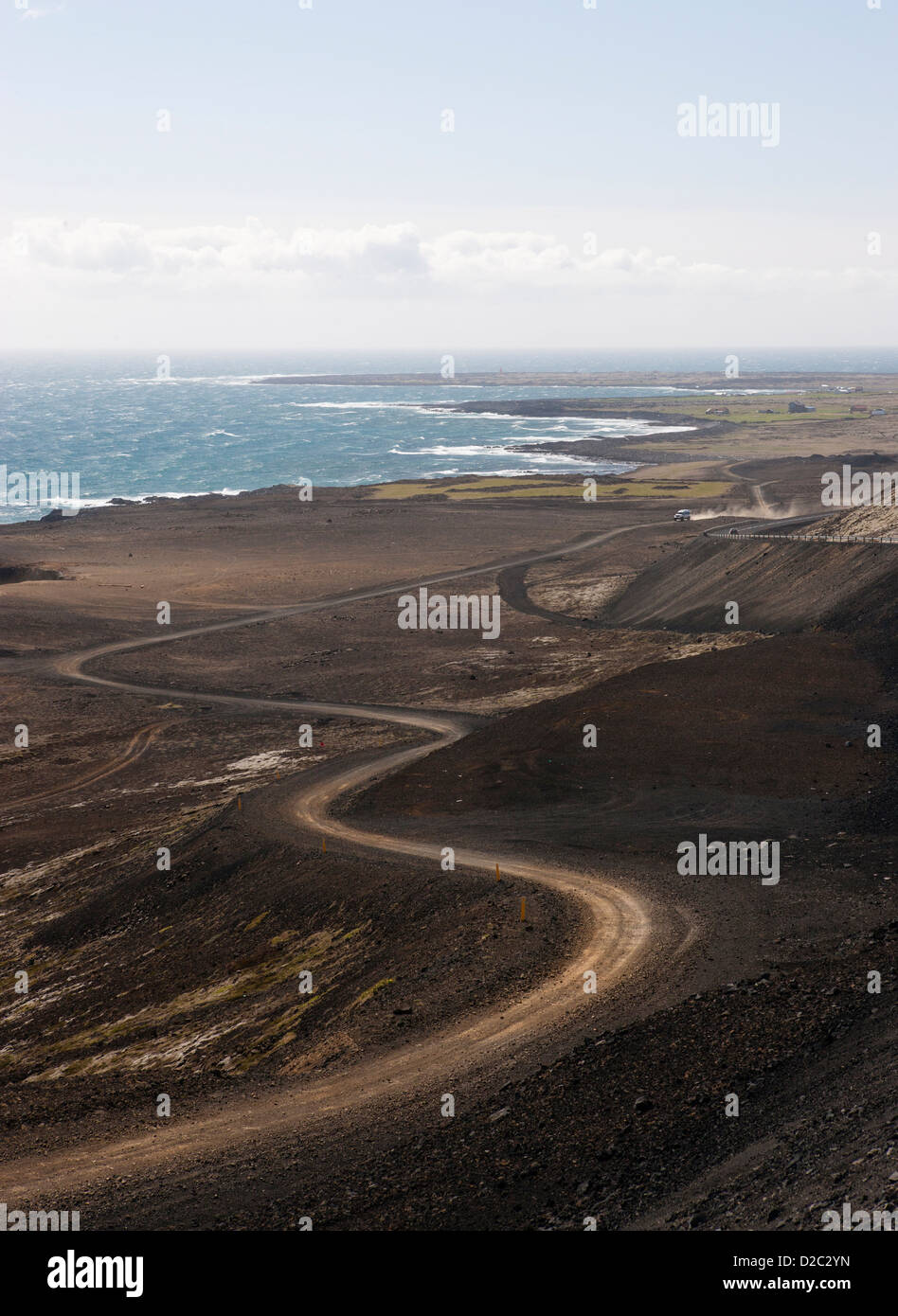 Un avvolgimento S-curva da una strada sterrata lungo la costa dell'Islanda che mostra il paesaggio e l'oceano con abbondanza di spazio di copia per il testo Foto Stock