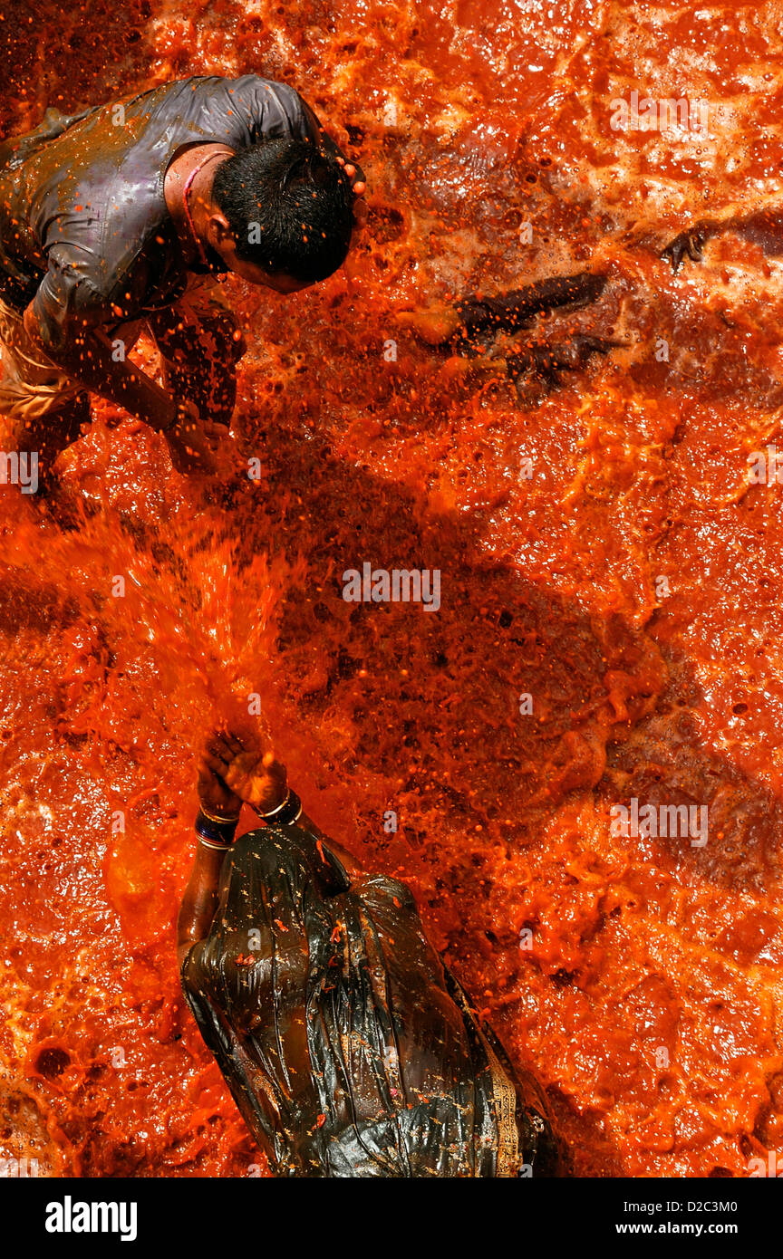 Donne devoti spruzzare acqua colorata a membri maschi della famiglia al tempio Dauji In Uttar Pradesh, India Foto Stock Donne devoti spruzzare acqua colorata a membri maschi della famiglia al tempio Dauji In Uttar Pradesh, India Foto Stock