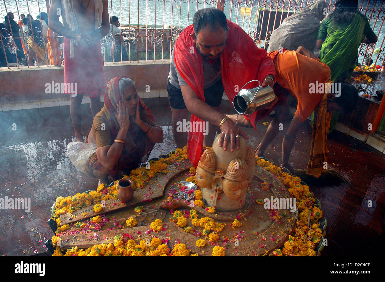 Indian pellegrini pregano offrendo acqua al Signore Shiva Tempio Ujjain, India Foto Stock