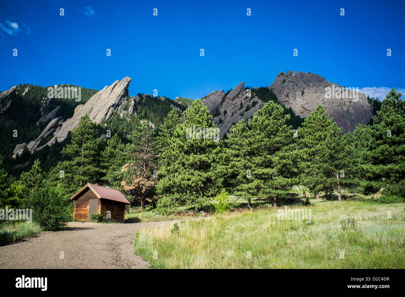 Il Flatiron Mountains sorge in un cielo blu chiaro. Una piccola capanna di legno è in primo piano. Foto Stock