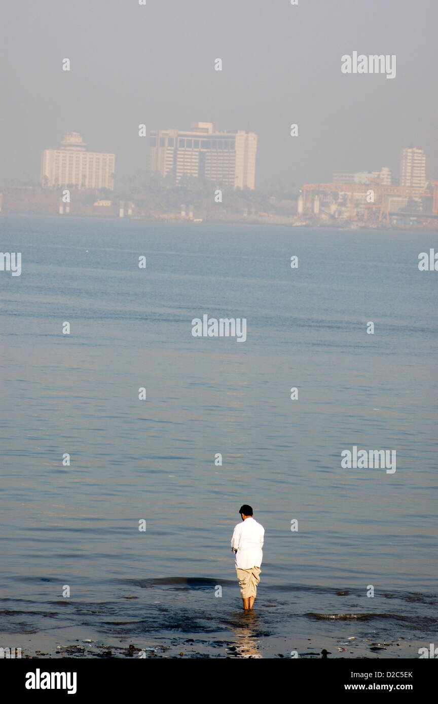Uomo di eseguire la mattina Pooja in riva al mare, India Foto Stock