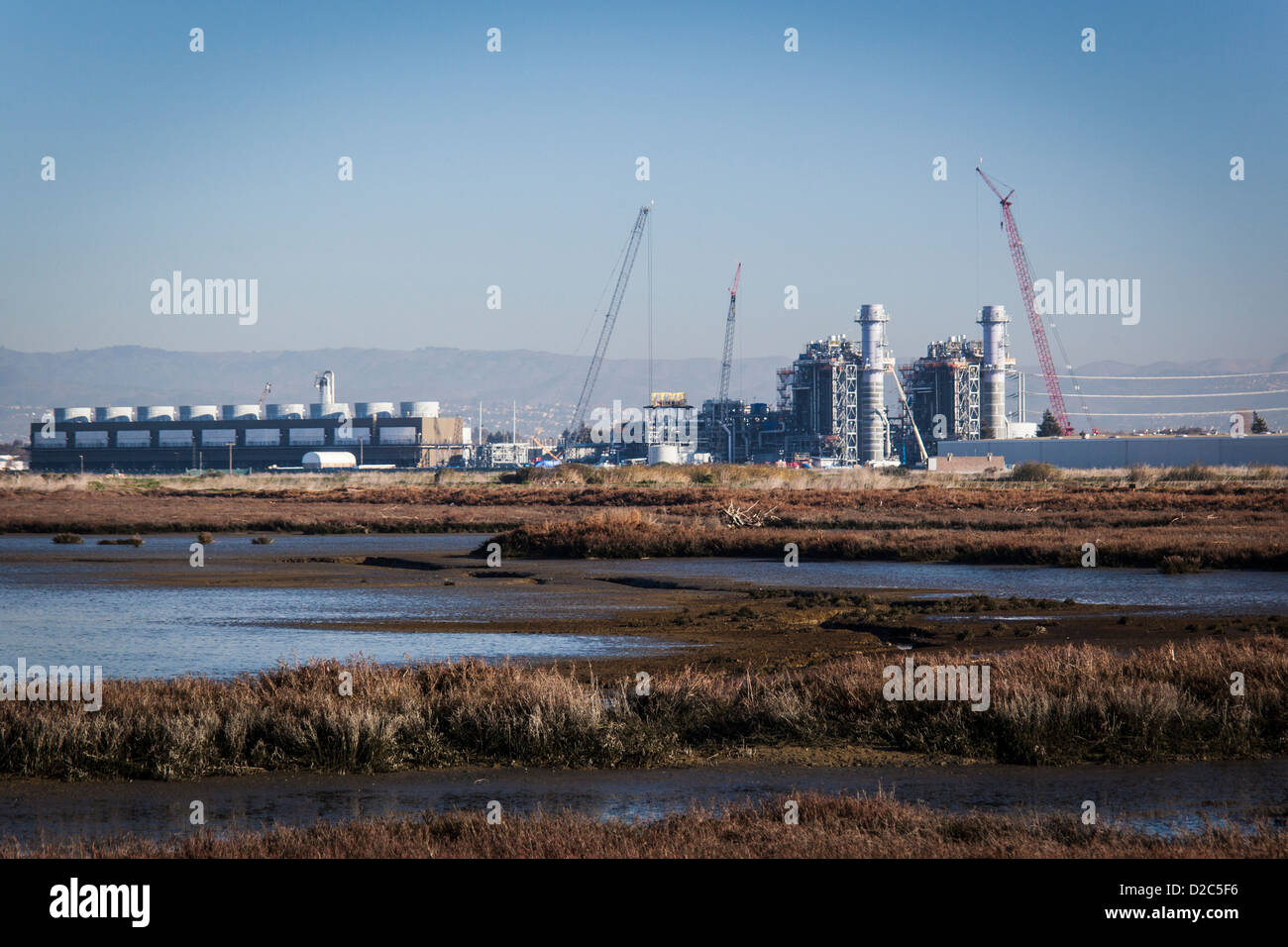 Impianto di alimentazione in costruzione in corrispondenza di un bordo di una palude salata e wetland Wildlife Refuge sulla Baia di San Francisco. Foto Stock