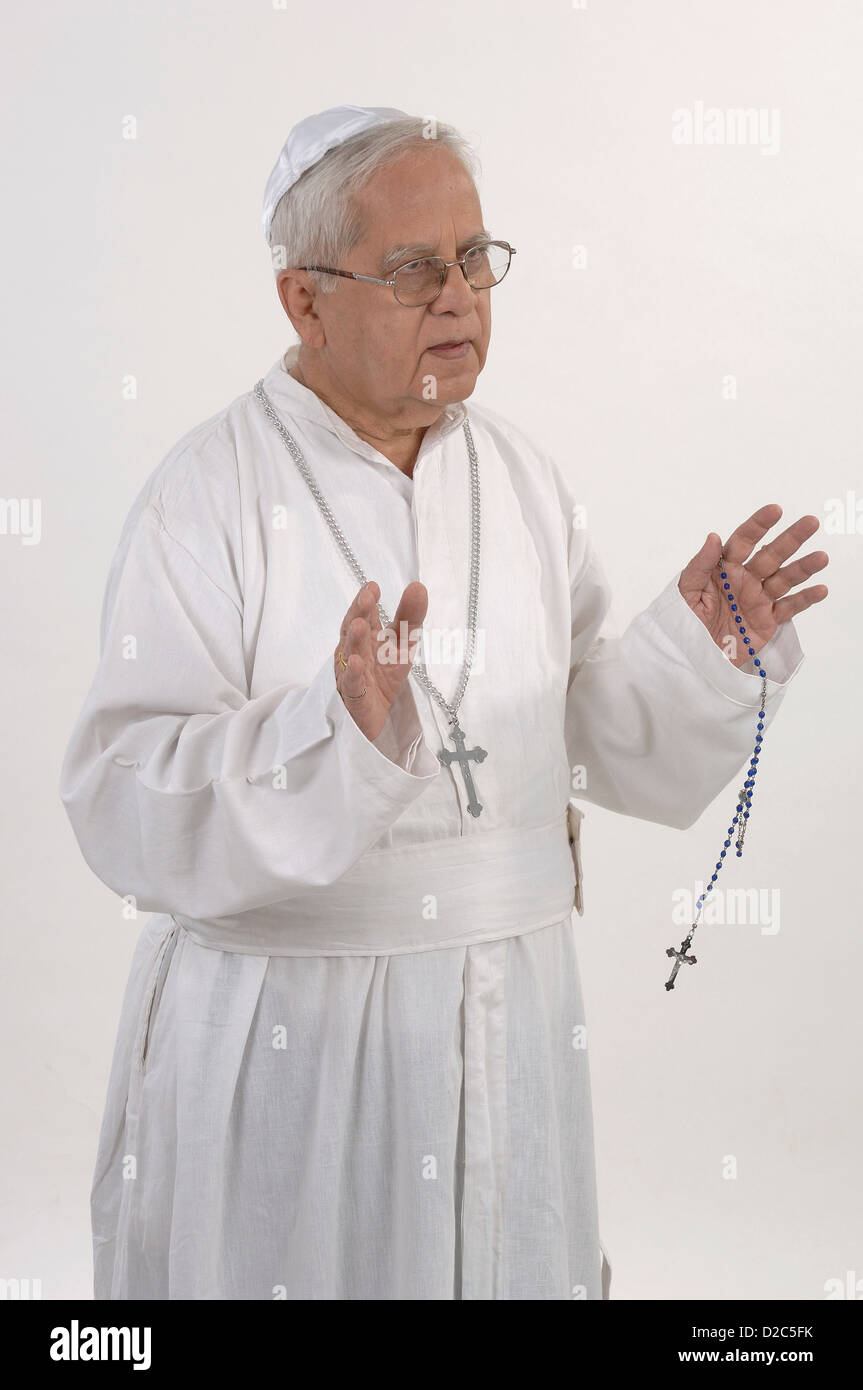 L'uomo vestito di tunica bianca e la preghiera Cap. Tenendo il Rosario Foto Stock