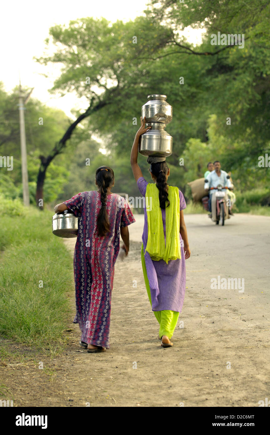 Le donne che trasportano acqua potabile dal tubo ben al di Ralegan Siddhi vicino a Pune, Maharashtra, India Foto Stock