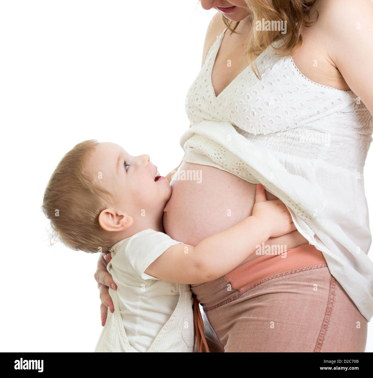 Little Boy abbracciando la gravidanza della madre e del ventre cercando Foto Stock