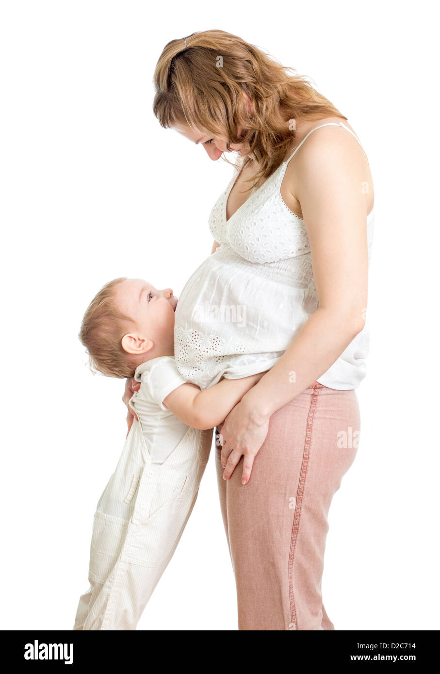 Little Boy abbracciando la gravidanza della madre e del ventre cercando Foto Stock