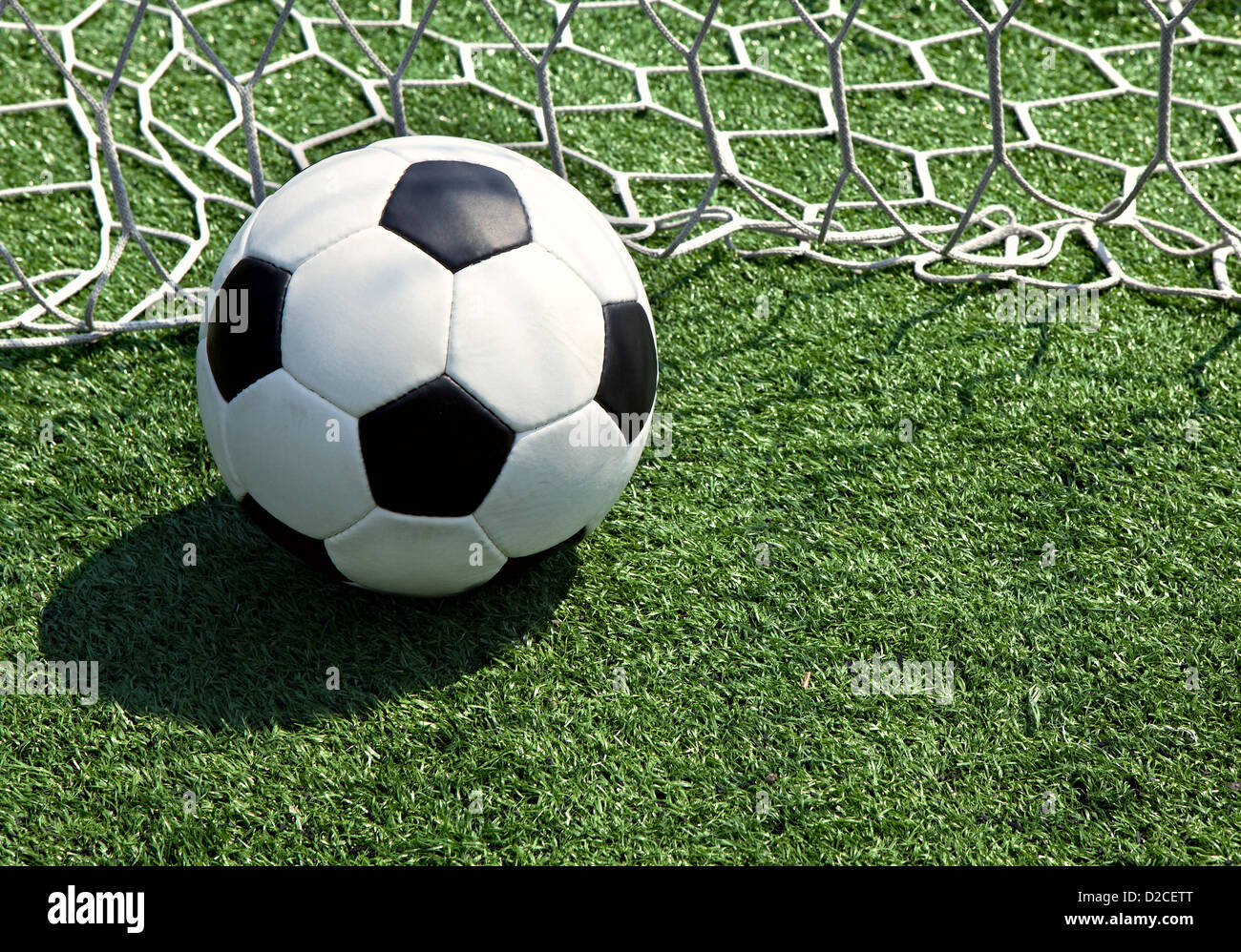 Pallone da calcio sul campo nella griglia Foto Stock