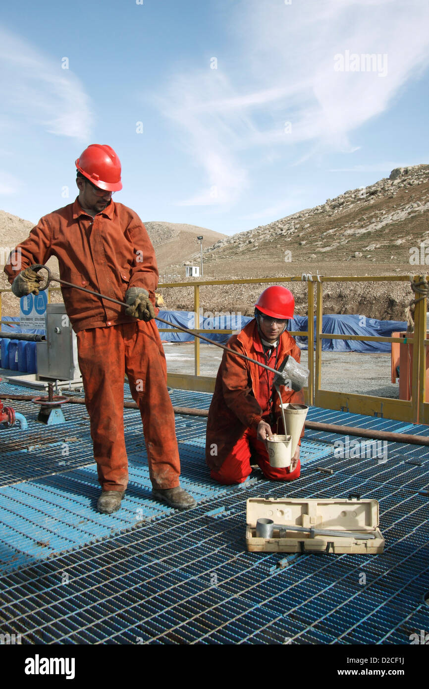 Onshore di esplorazione di petrolio e gas sito.curdi iracheni lavoratori prendendo campioni di fango da nel foro prima di accedere in laboratorio Foto Stock