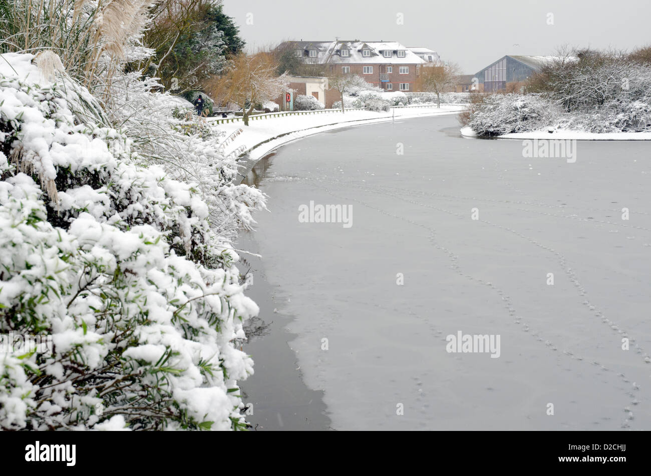 Snowy scena mostrando un lago congelato a Mewsbrook Park, Littlehampton West Sussex, in Inghilterra. Foto Stock