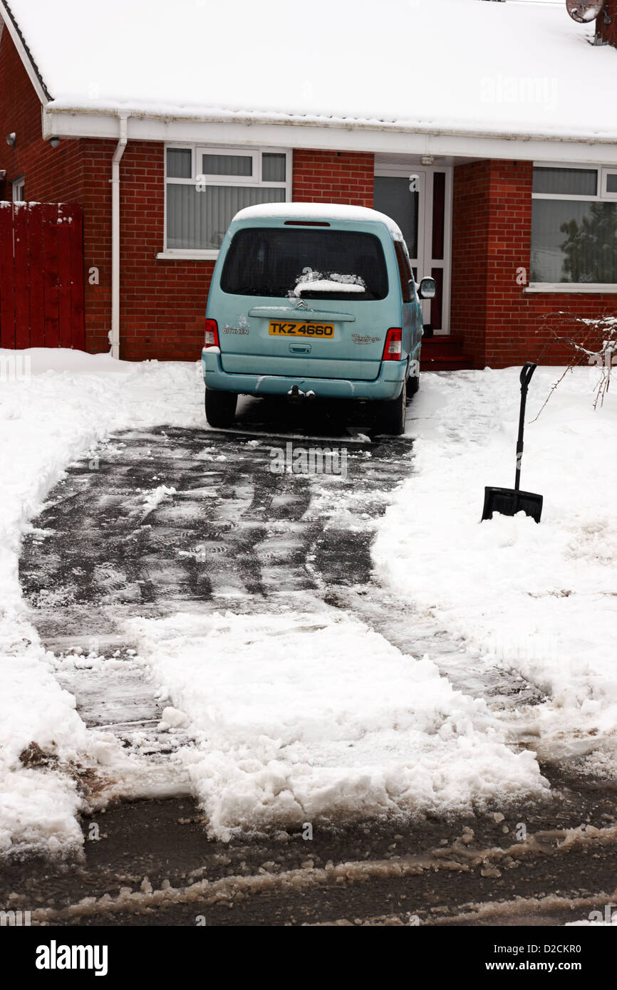 Cancellazione vialetto di neve in giardino frontale di una casa Newtownabbey Regno Unito Foto Stock