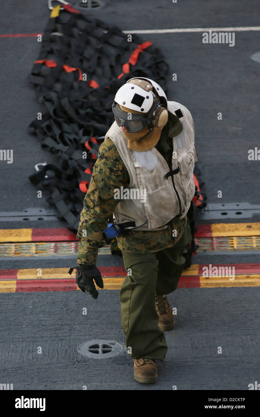 Un Marine dal 26 Marine Expeditionary Unit si muove un cargo net attraverso il ponte di volo a bordo di un assalto anfibio nave USS Kearsarge (LHD 3) durante una delle munizioni sul carico. Kearsarge sta conducendo esperimenti in mare in preparazione per una distribuzione programmata t Foto Stock