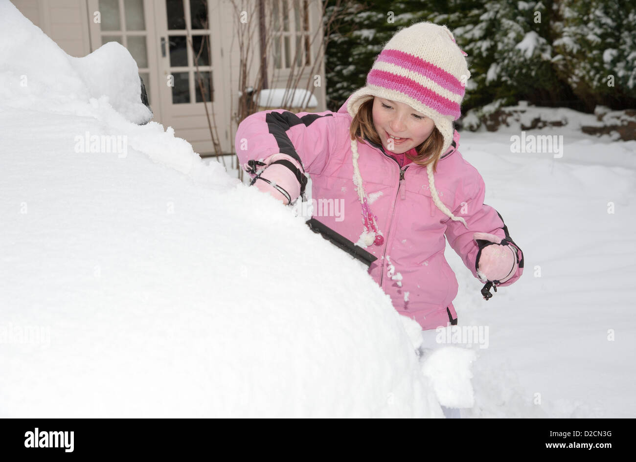 Ragazza giovane la rimozione di neve da una macchina Foto Stock