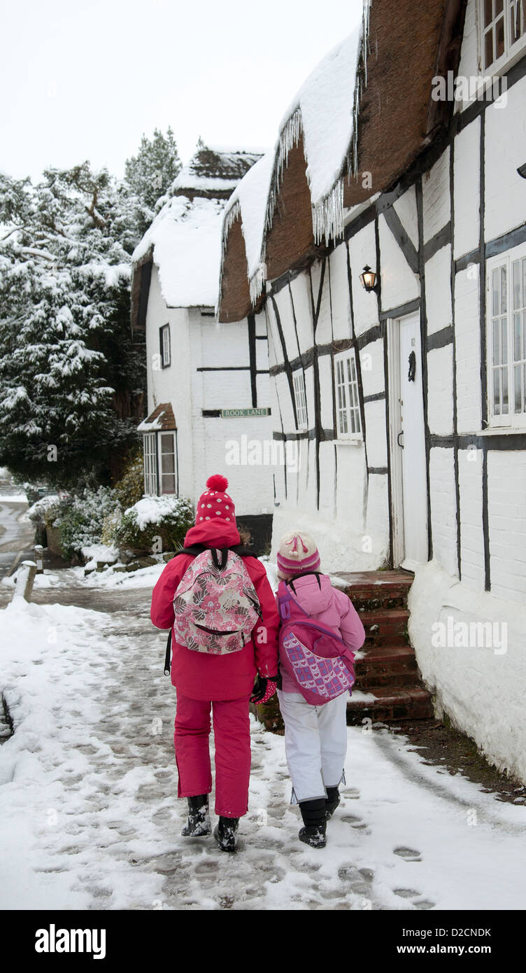 Andare a scuola a piedi in un freddo inverno mattina con pavimento ricoperto di ghiaccio e neve. Foto Stock